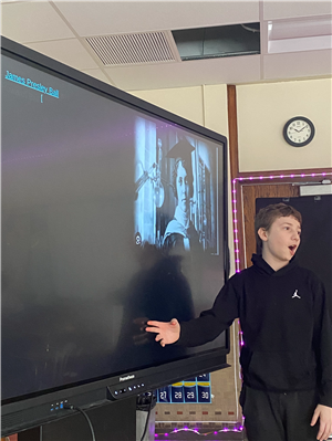 A student presents information he learned as part of a classwide presentation about famous Black contributors to STEM fields.